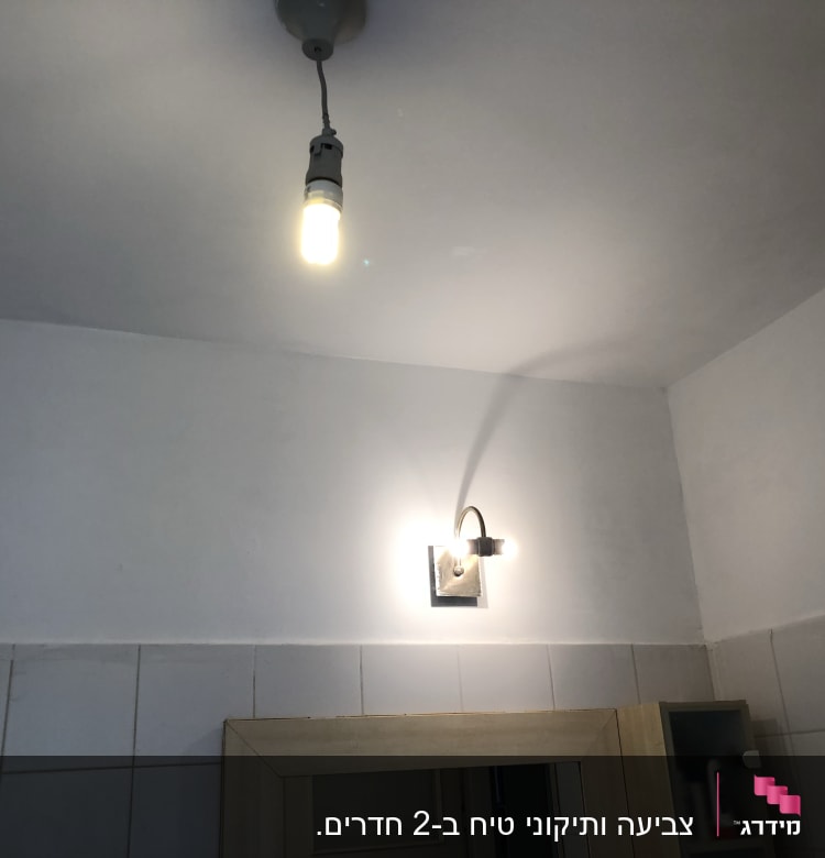 קיר צבוע בלבן עם מנורה תלויה